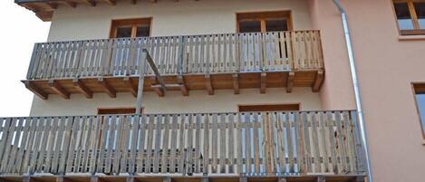 A multi-story building with balconies, wooden railings, and a sign reading "LE BREOUIN".
