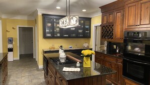 A kitchen with a central island, wooden cabinets, and a built-in oven.