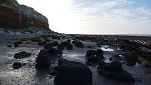 A rocky beach with large boulders and a wooden walkway. - Pets Stay Free 8 Berth lux van Heacham Beach (King's Lynn)