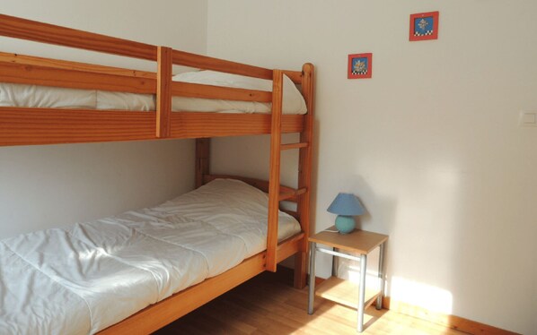 A bunk bed room with a small table and a lamp. - Comfortable individual lodgings in a natural setting. (GOUVILLE-SUR-MER)