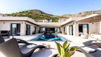 Una piscina al aire libre, una piscina climatizada, tumbonas