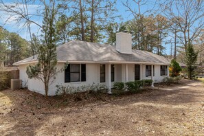 Stunning single-story home with a gabled roof and charming porch area.