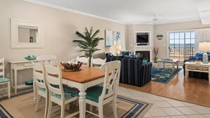 Un grand espace de vie comprenant une table à manger, des chaises, un canapé et un téléviseur.