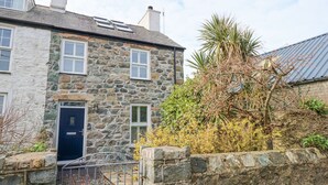 A stone house with a dark blue door, white shutters, and a metal gate. - Min Y Mor - Morfa Nefyn (Pwllheli)