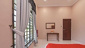 Un dormitorio con cama, una mesa de madera, un espejo y una puerta.
