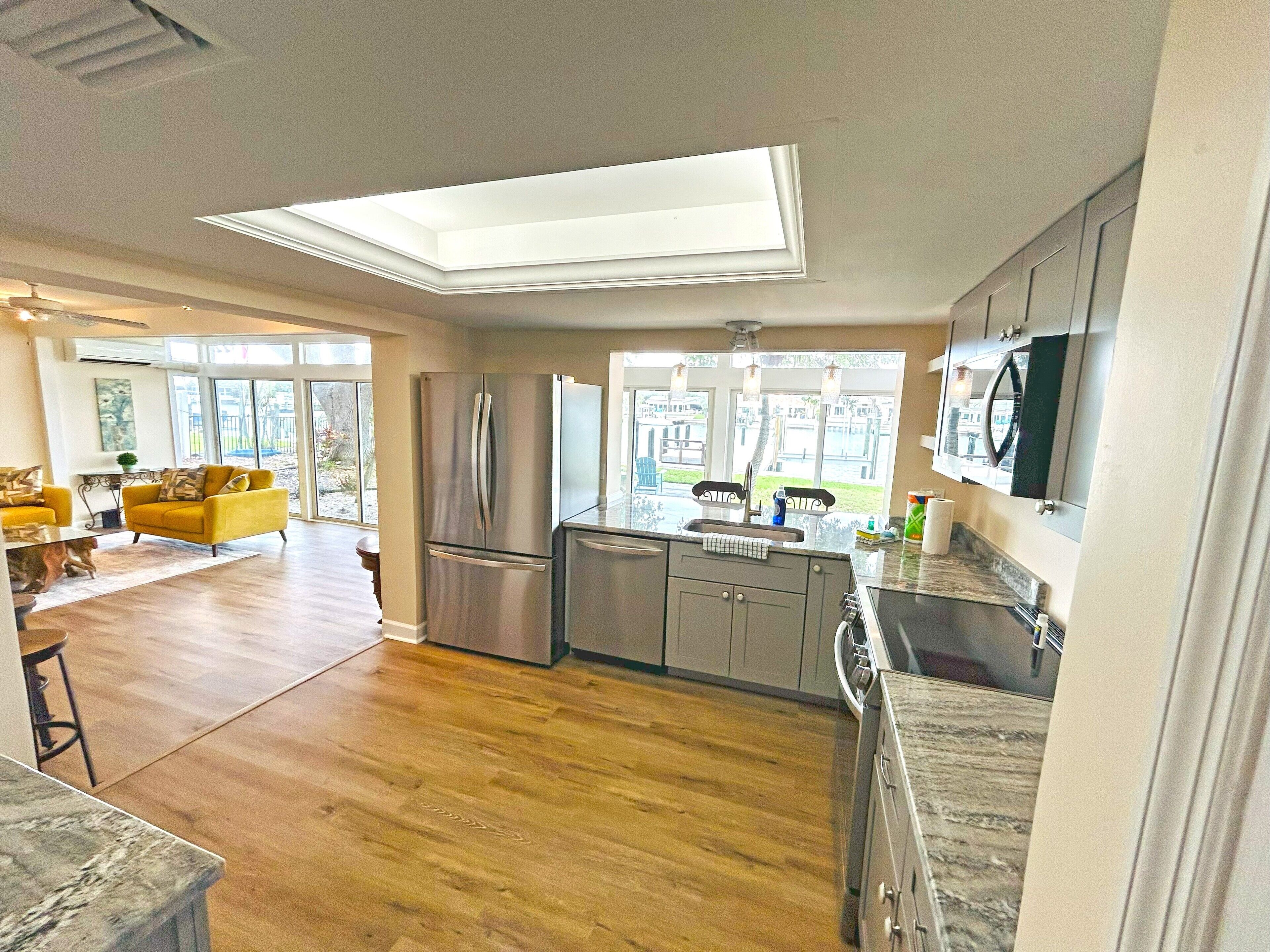 A modern kitchen with a skylight, stainless steel appliances, and a view of the outdoors.