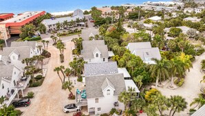 An aerial view of a coastal residential area with houses, palm trees, and a beach in the background. - Island Escape with Pool and Balcony! Near the Beach and Dining - Two Sisters (Holmes Beach)