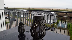 Ein Balkon mit Blick auf ein Wohngebiet und das Meer.