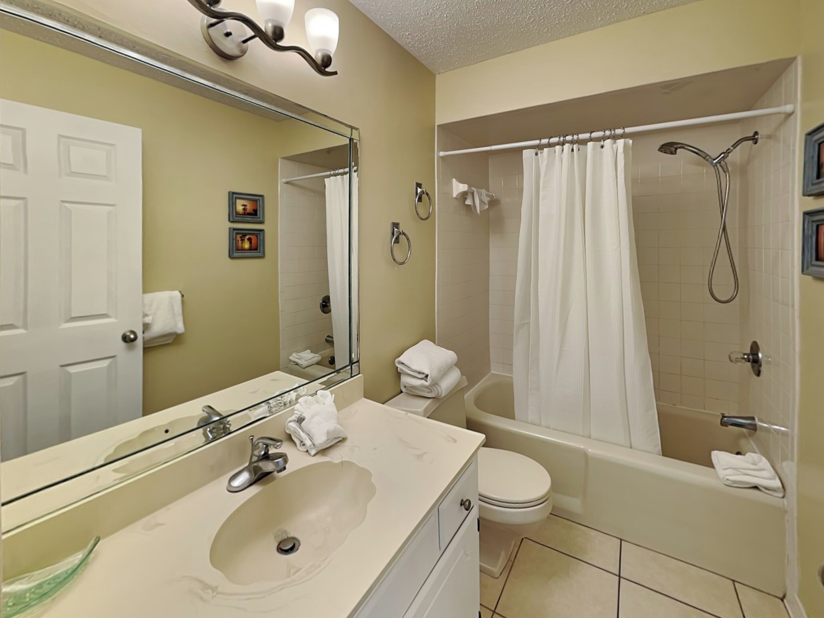 A bathroom with a sink, toilet, and shower.