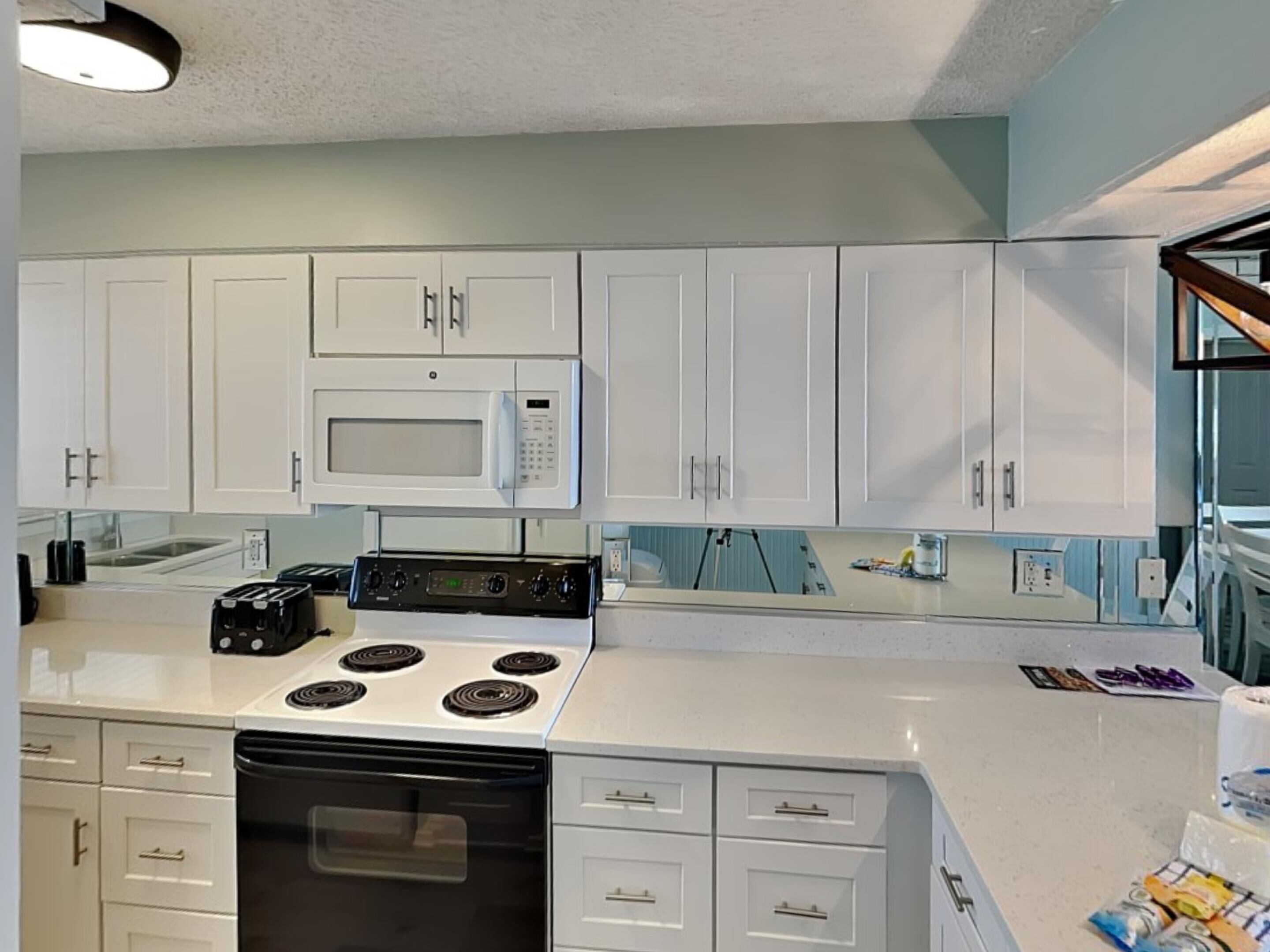 A kitchen with white cabinets, a microwave, a stove, and a dishwasher.