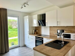 Fridge, microwave, oven, stovetop - House No. 18, Ferienhaus Fischerhus - Well-kept vacation home, sauna, south-facing terrace, (Wangerland)