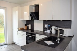 Fridge, microwave, oven, stovetop - House no. 24, Ferienhaus Fischerhus - Modern vacation home, sauna, south-facing terrace, (Wangerland)