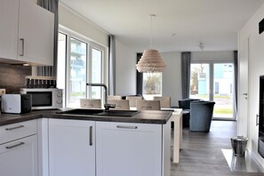 Fridge, microwave, oven, stovetop - House No. 16, Ferienhaus Deichgraf - Modern vacation home, sauna, south-facing terrace, (Wangerland)