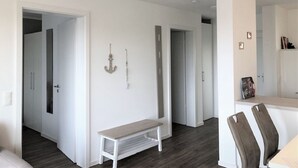 Um interior moderno com um banco, área de refeições e espaços abertos.