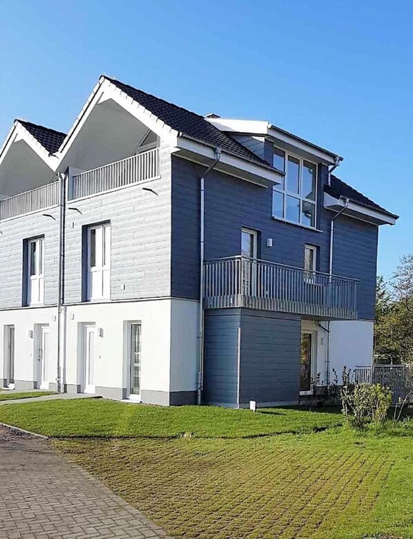 En bostadsbyggnad i två våningar med en balkong på övervåningen.