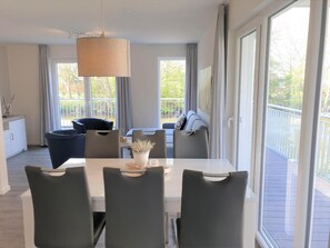 Un espace repas moderne comprenant une table, des chaises et un luminaire suspendu.