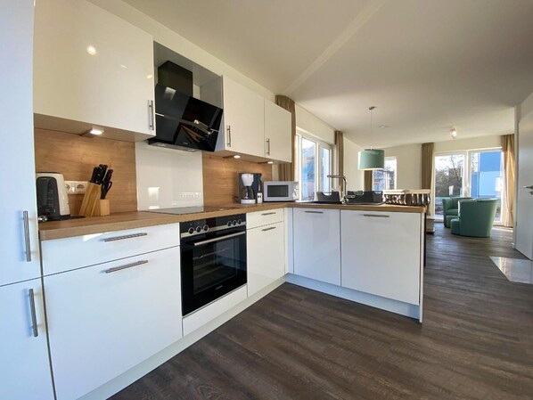 Fridge, microwave, oven, stovetop - House No. 12, Ferienhaus Deichgraf - Modern vacation home, sauna, south-facing terrace, (Wangerland)