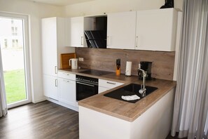 Microwave, oven, stovetop, dishwasher - House no.: 46, Ferienhaus Deichgraf - Modern vacation home, sauna, south-facing terrace, (Wangerland)