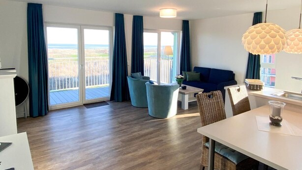 Una sala moderna con sofá, sillas, una mesa de comedor y un balcón con vistas.