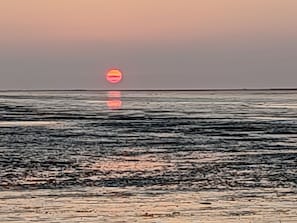 Un atardecer sobre un mar tranquilo con horizonte despejado.