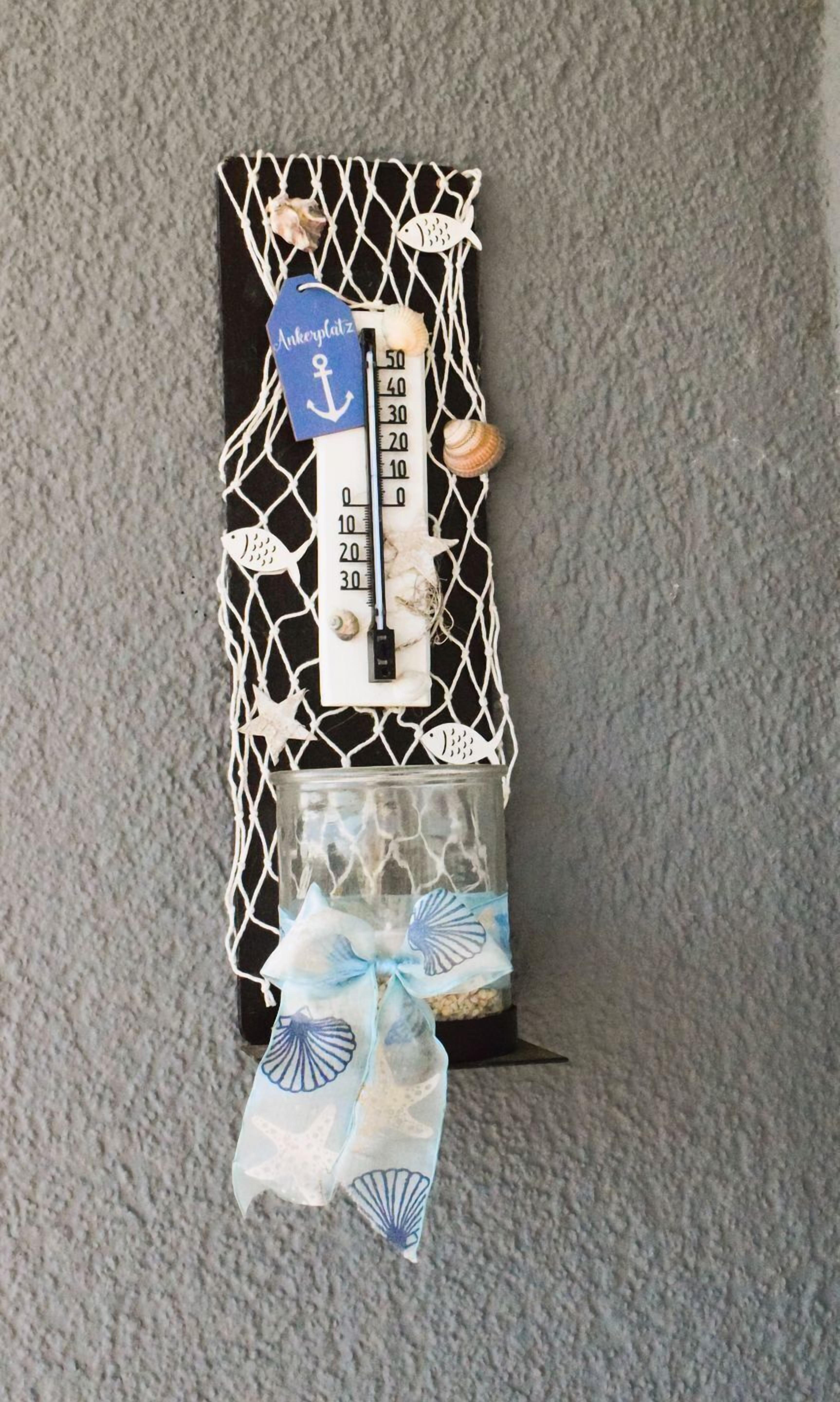 A decorative thermometer with a net-like structure, a scale, and a tag.