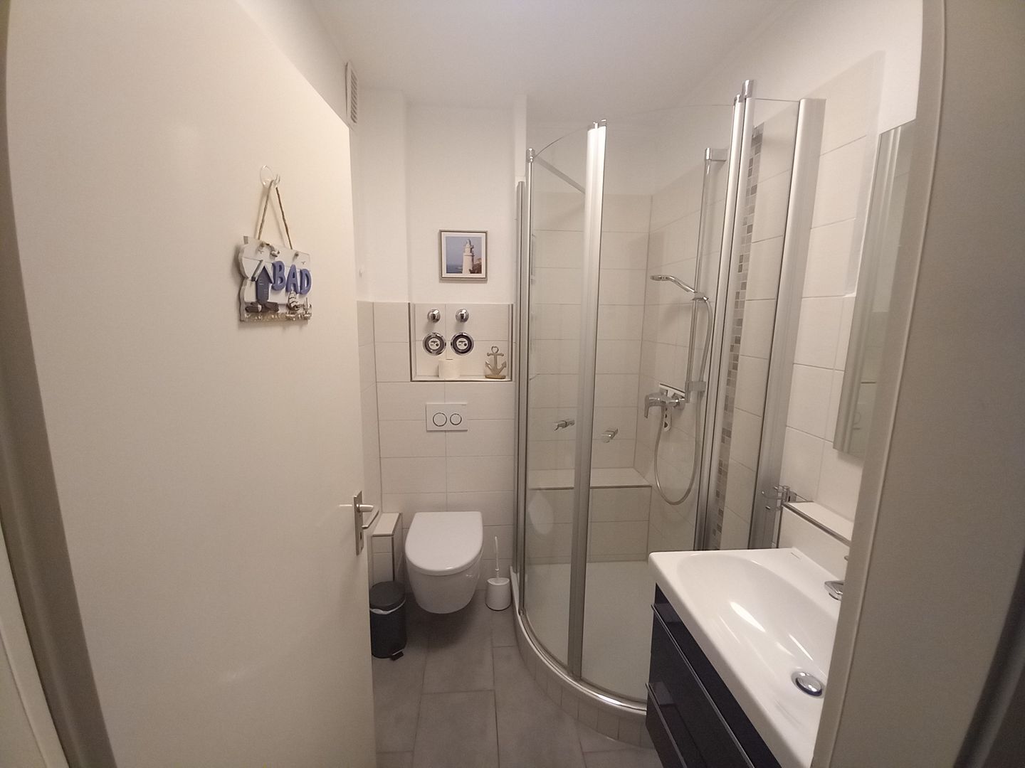 A bathroom with a toilet, a shower, and a sink.