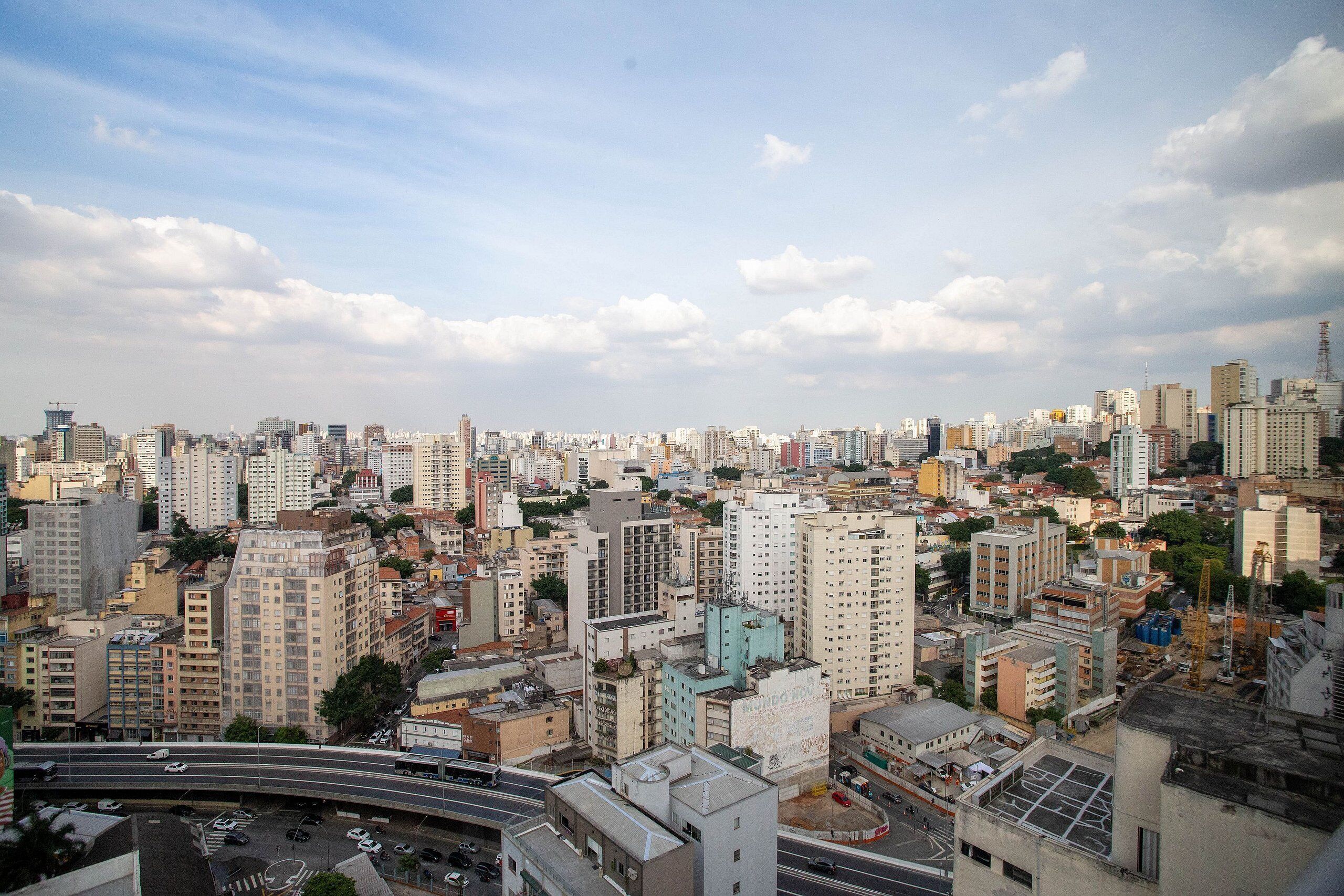 Un paisaje urbano con rascacielos, una autopista y una combinación de edificios residenciales y comerciales.