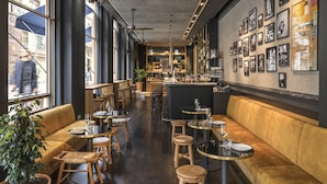 A restaurant with a long counter, wooden stools, and a bar area. - Hotel Casa Sagnier (Barcelona)