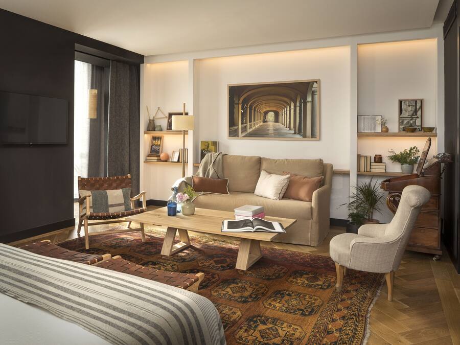 Un soggiorno moderno con divano, poltrona, tavolino e un quadro di grandi dimensioni appeso al muro.