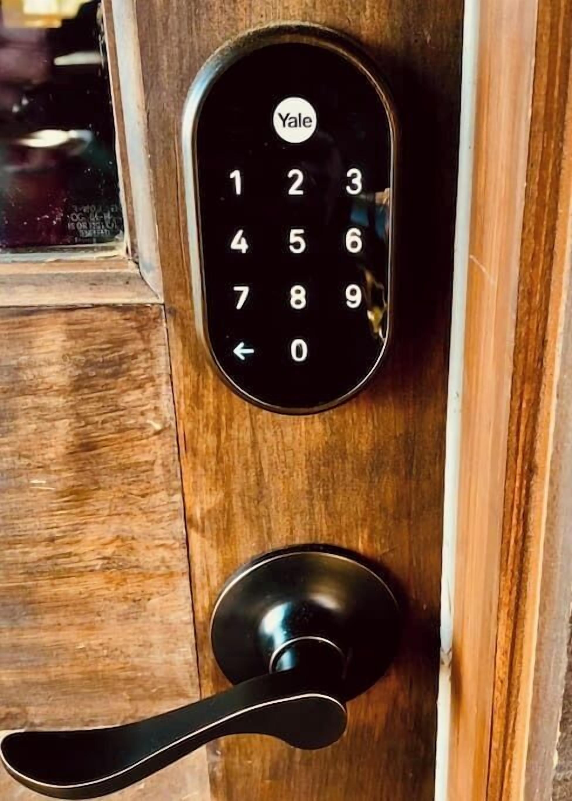 Une serrure de porte de marque Yale, dotée d’un clavier numérique et d’une poignée à levier.