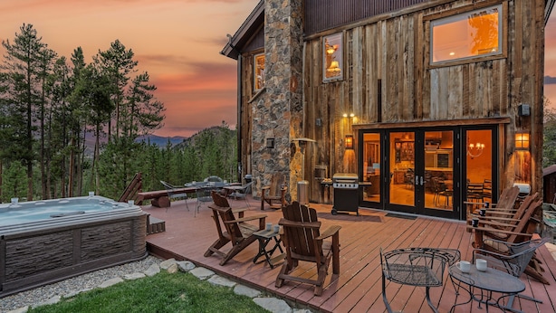 A wooden cabin with a deck, outdoor seating, and a hot tub. - Mountain Views + Hot Tub + Pet Friendly + Ski Shuttle - Alpenglow Peaks Lodge (Breckenridge)