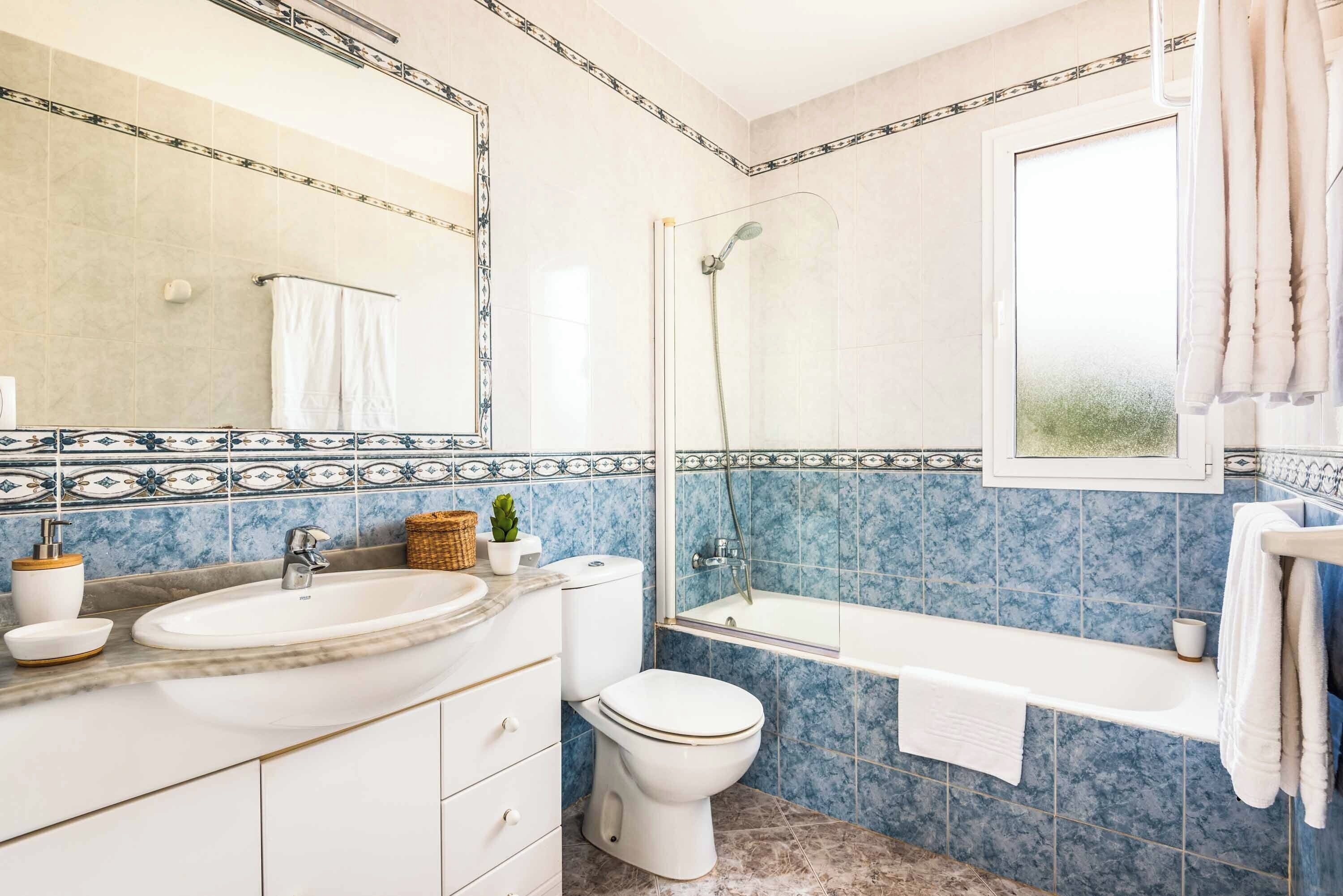 A bathroom with a sink, toilet, and shower.