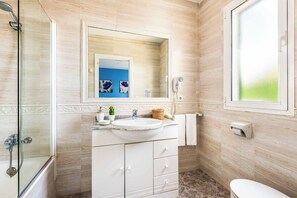 Enjoy a refreshing shower in the spacious bathroom with a shower, vanity, and large mirror.