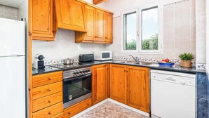 A kitchen with wooden cabinets, a microwave, a toaster, and a sink.
