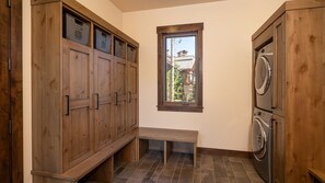 A laundry room with wooden cabinets, a bench, and a washing machine. - Designer Home + Ski in/Ski out + Hot Tub + Pet-Friendly | Epic Retreat (Breckenridge)
