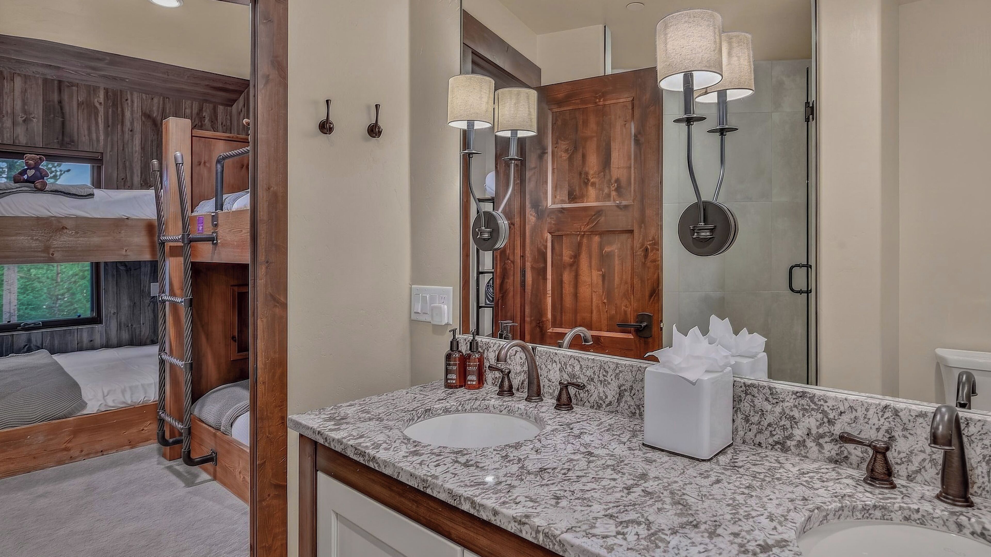 A bathroom with a wooden vanity, a large mirror, and a shower area.
