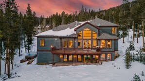 A large, multi-story house with a balcony, surrounded by snow and trees. - Spacious w/Mountain Views + Hot Tub + Close to Skiing - Mountain Gate (Breckenridge)