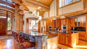 A spacious kitchen with wooden cabinets, a large island, and a dining area with bar stools.