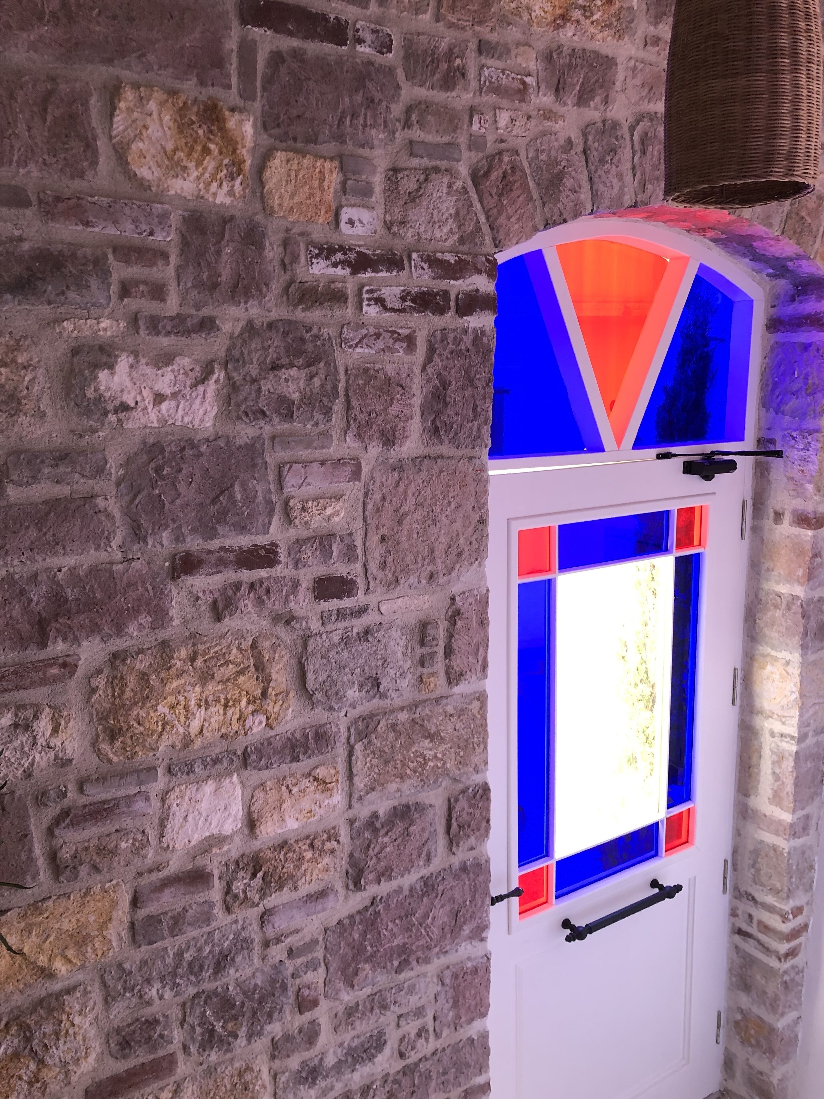 A white door with a colorful geometric design and a handle.