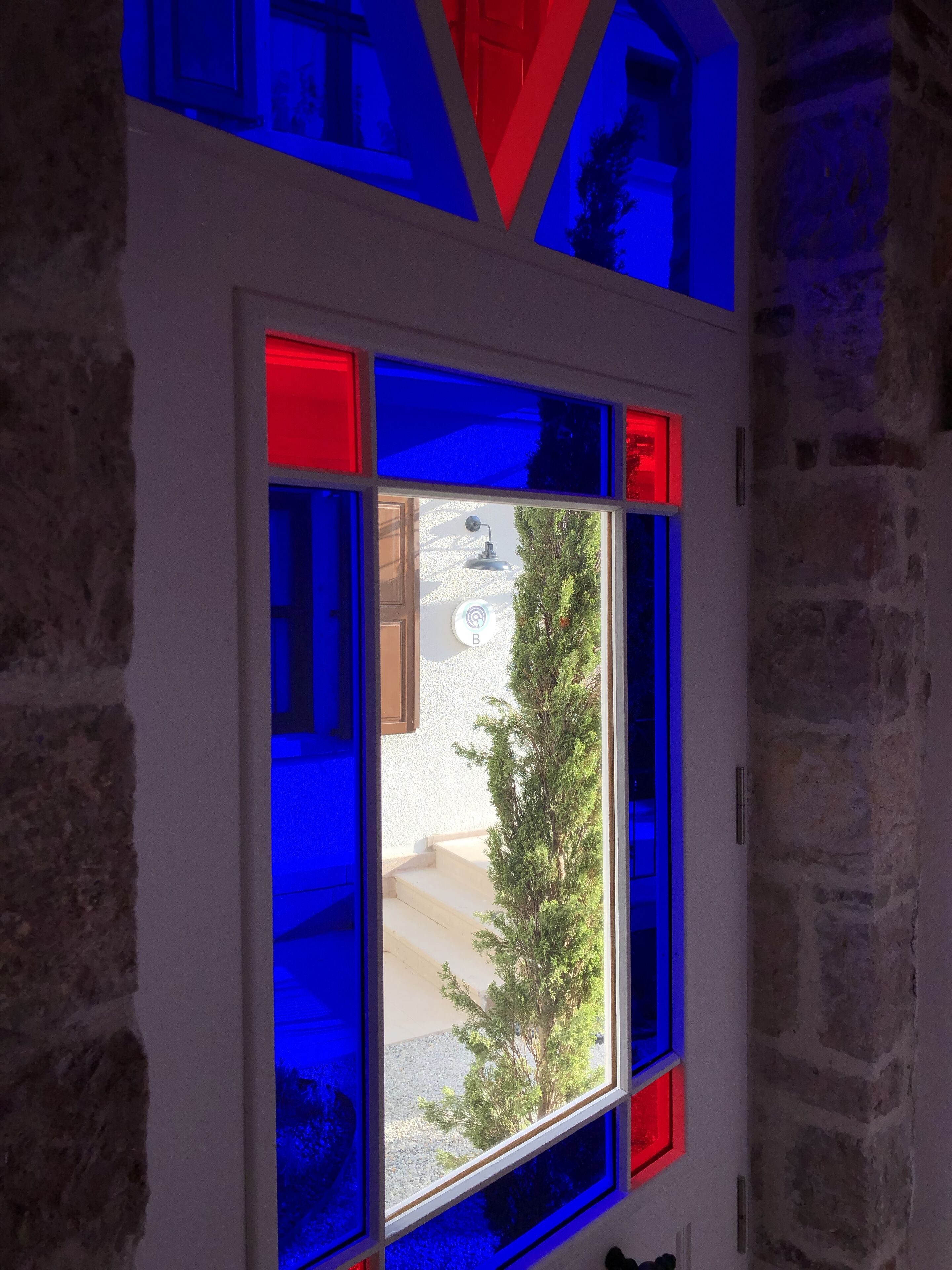 A window with a view of a tree and a building outside.
