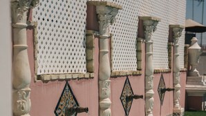 A pool with ornate columns and a decorative wall. - Apartamentos Abreu Suites (Seville)