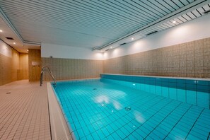 Una piscina interior con paredes y suelo de baldosas.