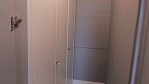A narrow hallway with a door on the left and a wall with a vertical panel on the right. - Strönwai - Perfect for sunbathing or enjoying the vacation life of the Strandstraße (Sylt)