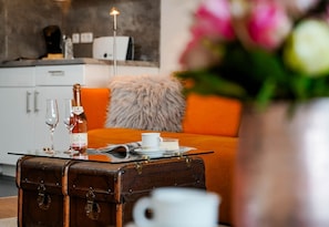 A cozy room with a bed, a suitcase, a bottle of wine, and glasses on a tray. - Sternenlicht - The apartment is located near the crossings to the pedestrian zone (Sylt)