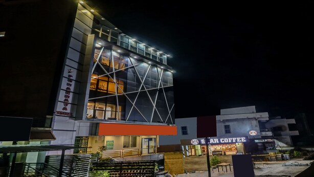 A modern building with a glass facade and a sign for 'Star Coffee' at the ground level. - Treebo Punarnava Bypass Road (Chikkamagaluru)