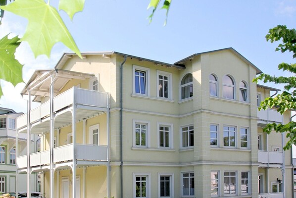Un edificio de varios pisos con balcones y ventanas amplias.
