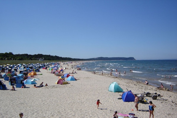 A beach with numerous tents and people enjoying the seaside. - Close to the beach, with balcony - Villa Strandmuschel FeWo 07 - Villa Strandmuschel (Göhren)