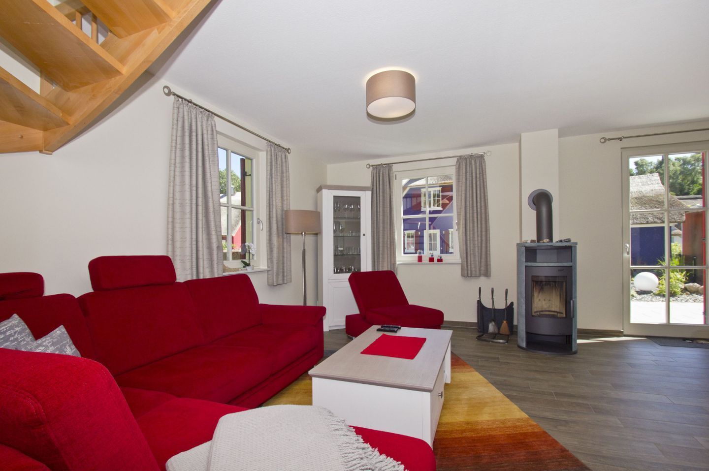 A living room with a red sofa, a white coffee table, and a fireplace.