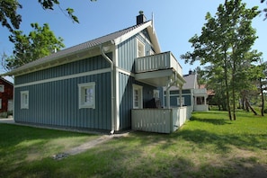 A two-story house with a balcony, a chimney, and a small porch.