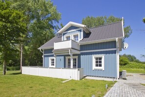 A two-story house with a balcony, a satellite dish, and a paved driveway. - Vacation home Frigga - comfortable Swedish house close to the beach with sea view - (Wiek)